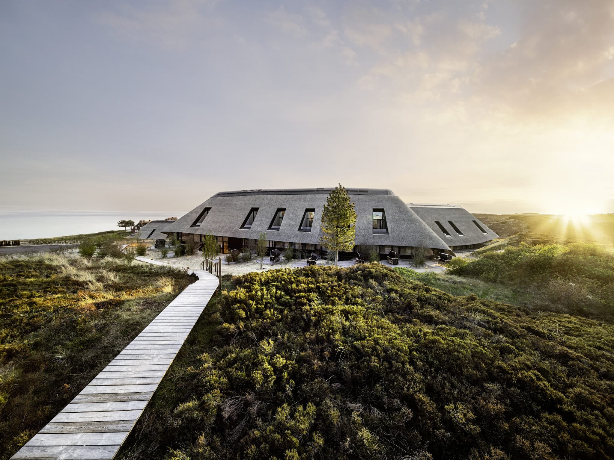 Blick auf den Ostfluegel des Lanserhof Sylt mit Sonnenuntergang